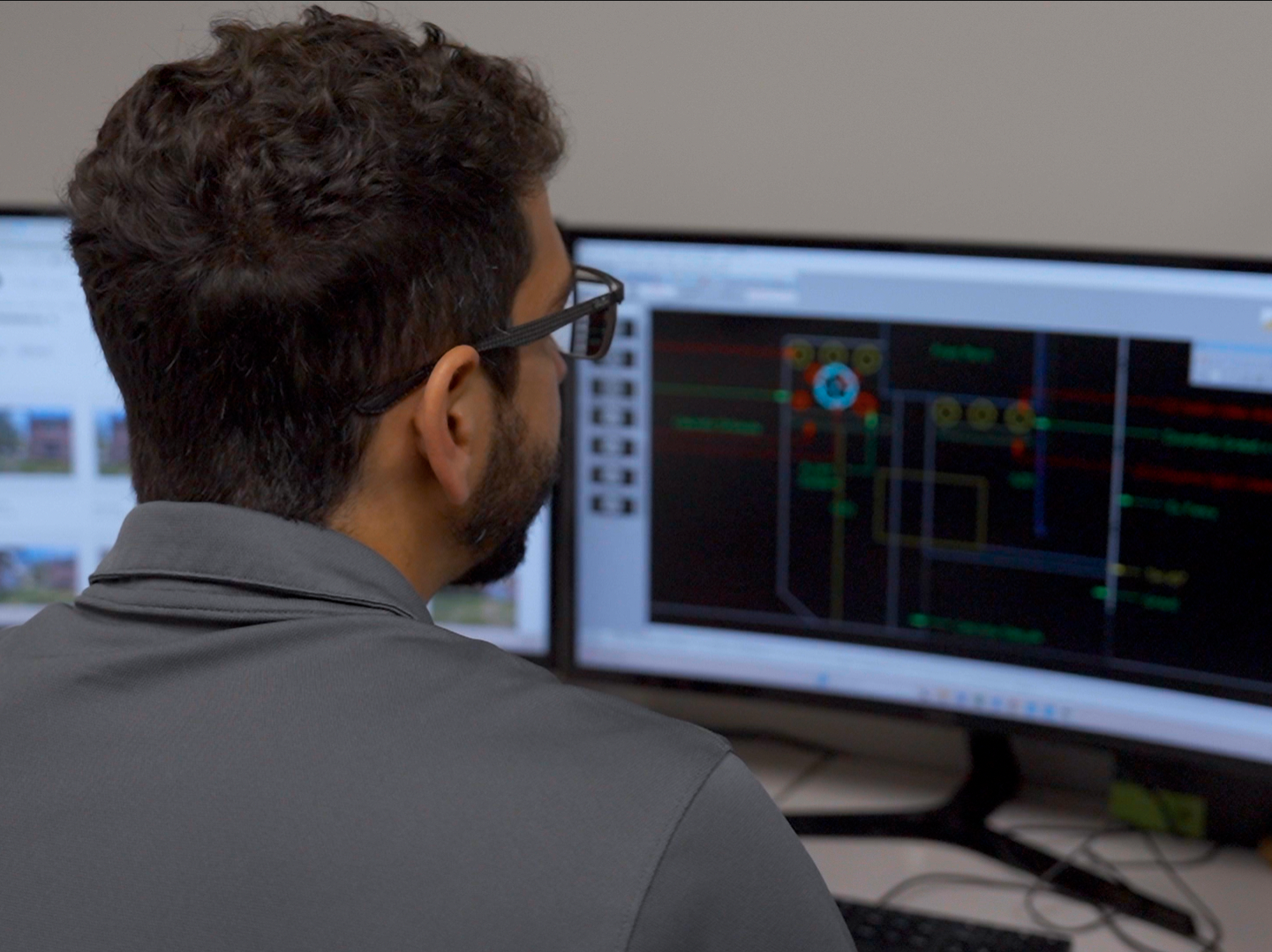 Elevate landscape architect reviewing CAD construction documents on dual monitors